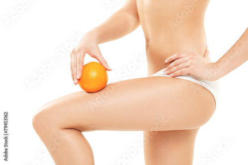 Young woman in underwear holding an orange showing absence of ce
