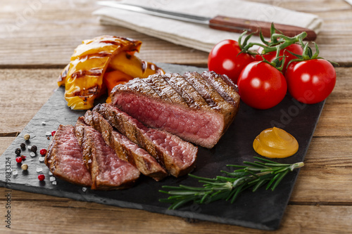 Zdjęcia grilled beef steak rare sliced with vegetables