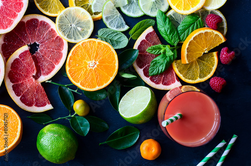 Fresh citrus slices and juice on black background top view © saschanti