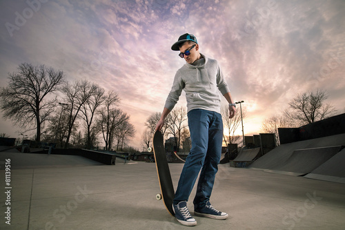 fajny-nastoletni-chlopak-z-deskorolka-w-skate-parku