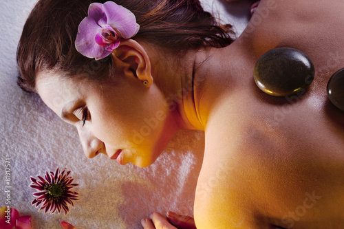 Poster, Tablou Young woman getting stone massage procedure.