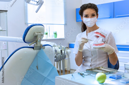 Zdjęcia Dentist in mask holding green apple.
