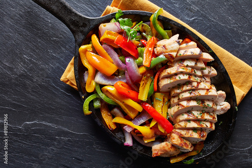 Zdjęcia mexican grilled chicken fajitas in iron skillet shot from overhead on slate