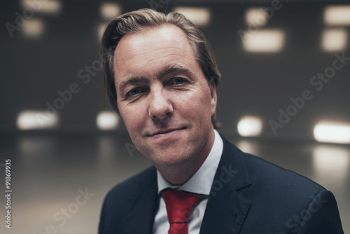 Arrogant entrepreneur wearing suit with red tie in <b>empty room</b>. - 500_F_91869935_0isPXjHSf79MG8YlJjPZMaE992QeFYn5