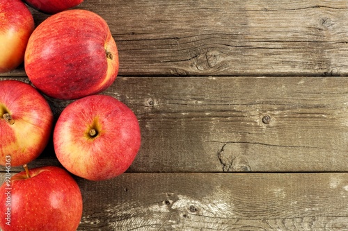 Freshly harvested apples, side border on rustic aged wood background Poster
