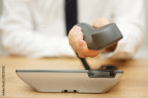 businessman is showing telephone headset to you, concept of supp