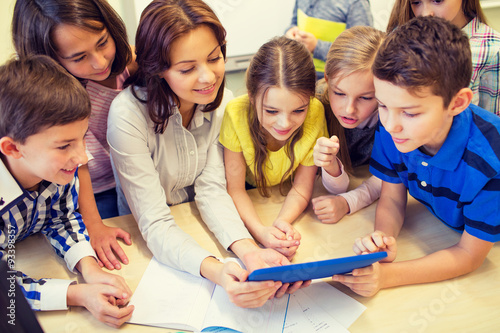 Zdjęcia group of kids with teacher and tablet pc at school