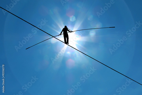 Highline walker in blue sky concept of risk taking and challenge
