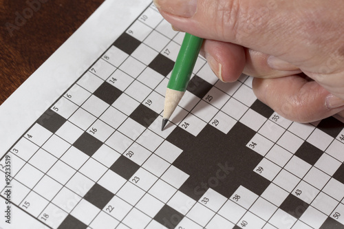 "An elderly woman is doing crossword puzzle. It is a good ...