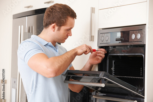 Man Repairing Domestic Oven In Kitchen © highwaystarz
