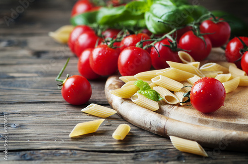 Poster Raw intergal pasta with fresh tomato and basil