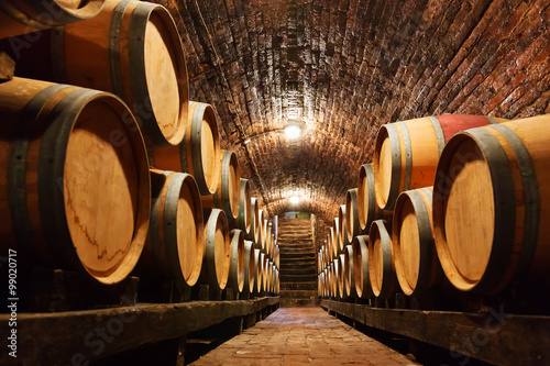 Poster Oak barrels in a underground wine cellar