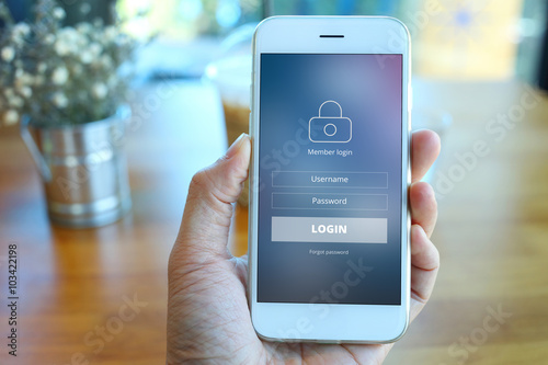 Hand holding smartphone with mebber loging screen