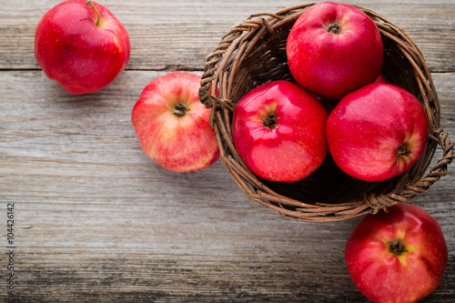 Ripe red apples on wooden background.