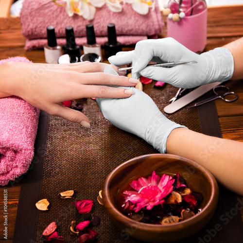 Zdjęcia Closeup finger nail care by manicure specialist in beauty salon.
