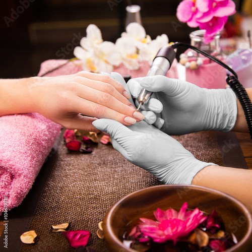 Zdjęcia Closeup finger nail care by manicure specialist in beauty salon.