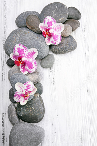 Lacobel Spa stones and orchids on wooden background