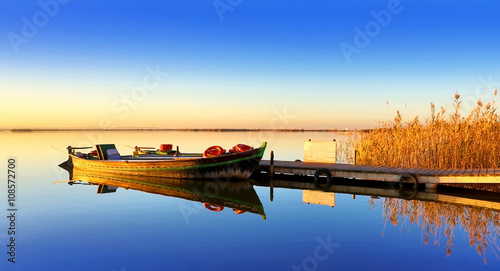 Fototapeta barca en el lago azul