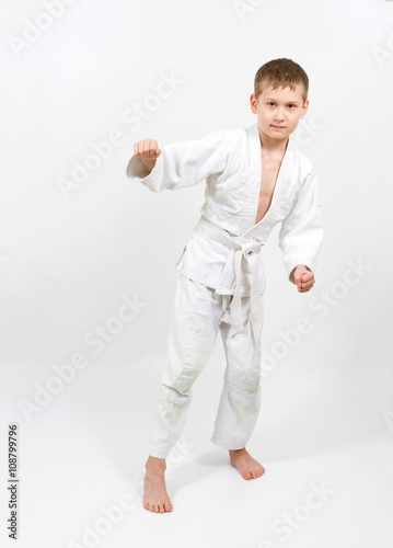 Karate boy in white kimono fighting © volkovslava