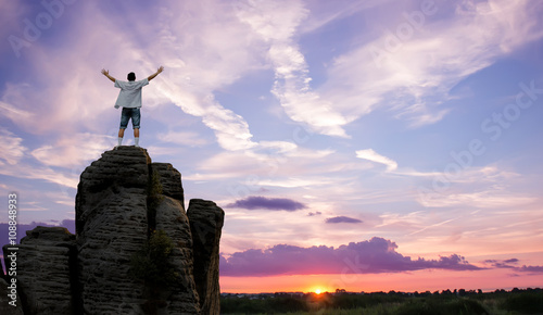 Winner man standing on the top of mountain panoramic view