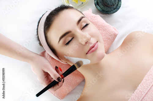 Poster, Tablou Woman with clay facial mask in beauty spa.