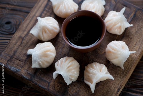 Plakát, Obraz Rustic wooden serving board with steamed dim sums, closeup