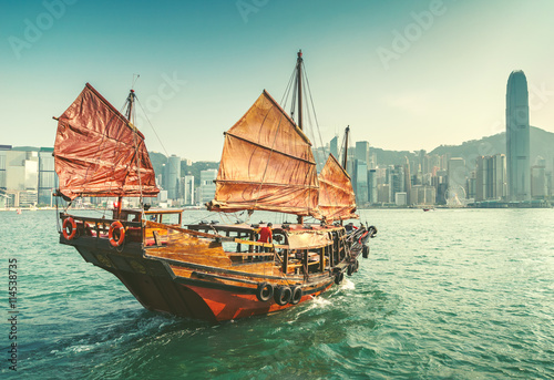 Poster Scenic view over Hong-kong skyscprapers and a junkboat sailing