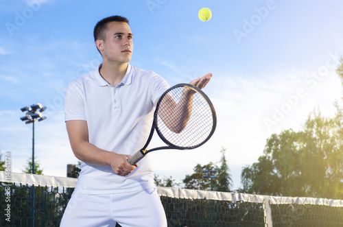 Jeune joueur de tennis lancer la balle en l'air, au service, mise au point s