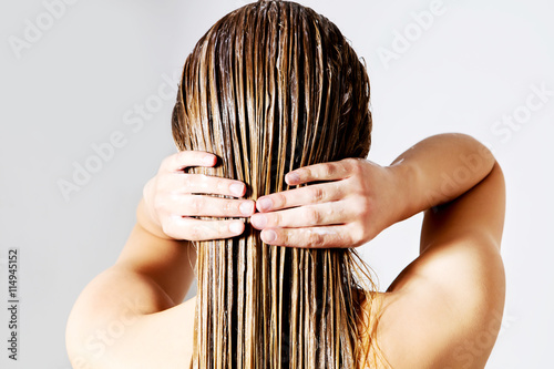 Zdjęcia Woman applying hair conditioner. Isolated on white.