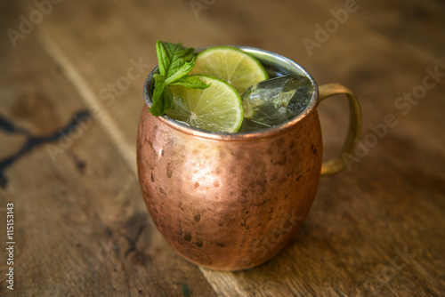 Poster Moscow mule cocktail in a copper mug with lime slices and mint sprigs