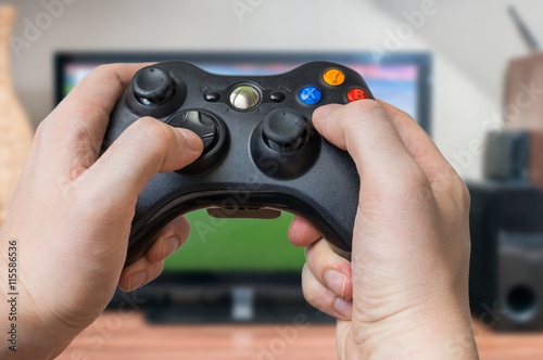 Poster Young man is playing video games and holds joystick or controller