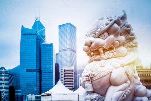 Poster modern skyscrapers with a majestic stone lion in the foreground,hong kong,china