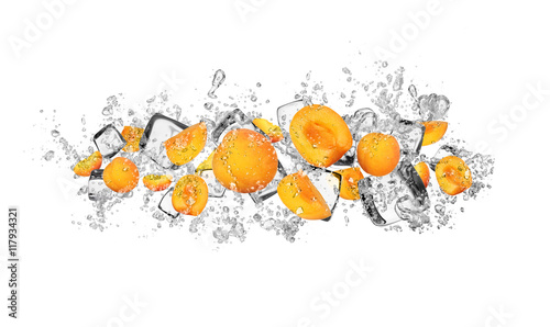 Fototapeta Apricots in water splash on white background