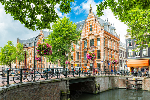 Poster Typical canal side cityscape of Amsterdam, opposite from the 17th century HQ of