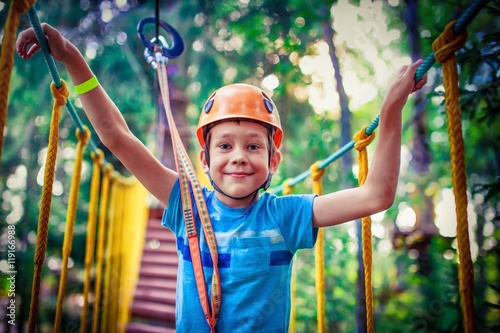 happy boy on the zip line. proud of his courage the child in the high wire park