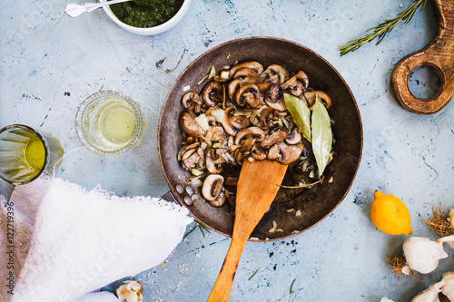 Fried mushrooms cast-iron pan on table.