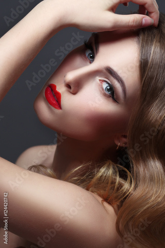 Fashion beauty portrait of gorgeous girl with curls and red lipstick in the style of Hollywood on a black background © ksi