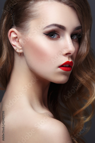 Fashion beauty portrait of gorgeous girl with curls and red lipstick in the style of Hollywood on a black background © ksi