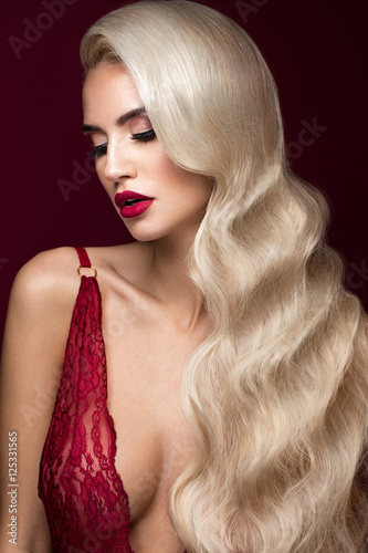 Beautiful blonde in a Hollywood manner with curls, red lips, red lingerie