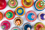 Top view of colorful painted handmade pottery lids on white background
