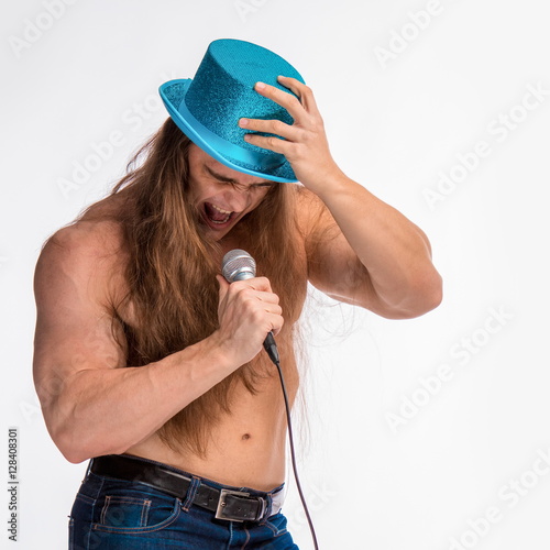Poster singer bodybuilder shirtless with long hair in a blue hat with a microphone on a