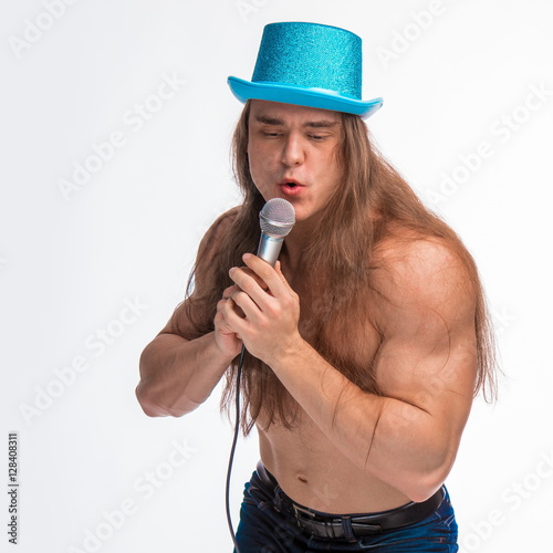 Poster singer bodybuilder shirtless with long hair in a blue hat with a microphone on a