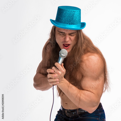 Poster singer bodybuilder shirtless with long hair in a blue hat with a microphone on a