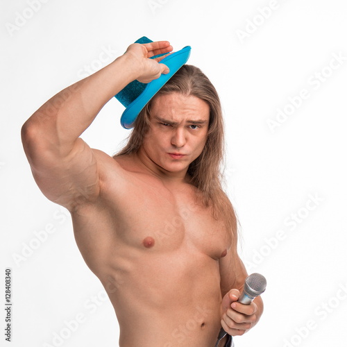Poster singer bodybuilder shirtless with long hair in a blue hat with a microphone on a