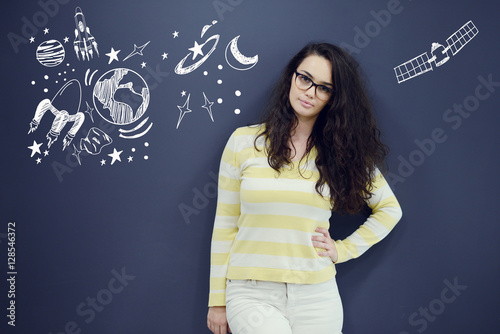 Poster Young thinkful woman on blue gray background with universum icons