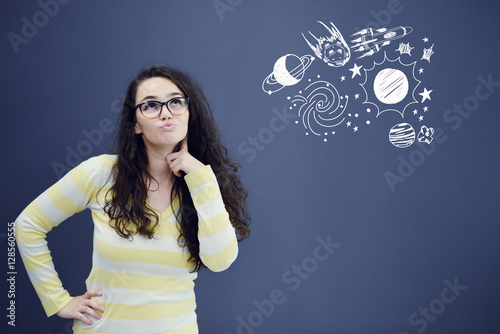 Poster Young thinkful woman on blue gray background with universum icons