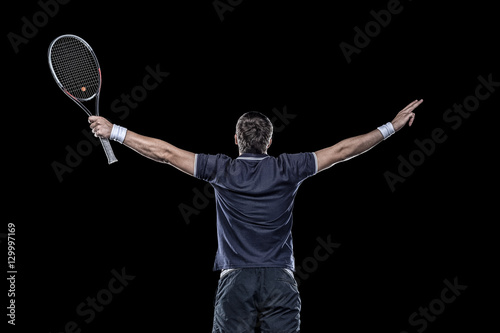 Obraz na plátně Tennis player with hands up isolated on black