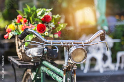 close up vintage bicycle with bouquet flowers in basket in vintage tone style