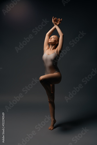Obraz Fotograficzny Sexy gymnast in ecru bodysuit gray background shot