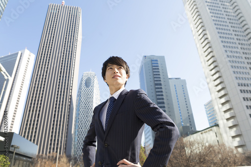 男性 ビジネスマン ポートレート 真剣 新宿高層ビル背景 真剣 やる気 挑戦チャレンジ